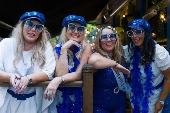 A hen party in blue at the rail of the heated terrace